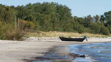 Small fishing boat is moored on a sandy beach