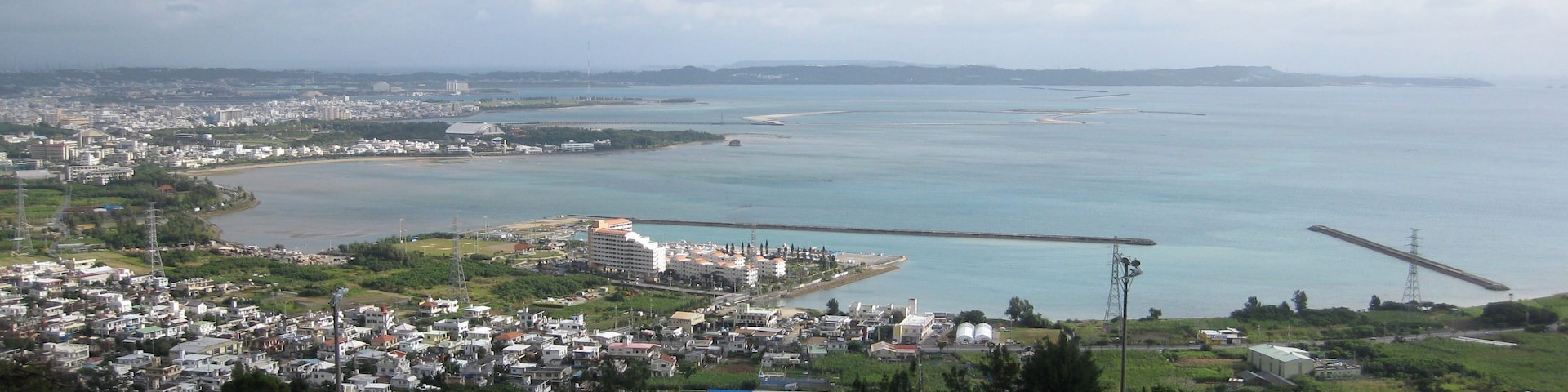 A coastal cityscape with a bridge, residential areas, and a large body of water.