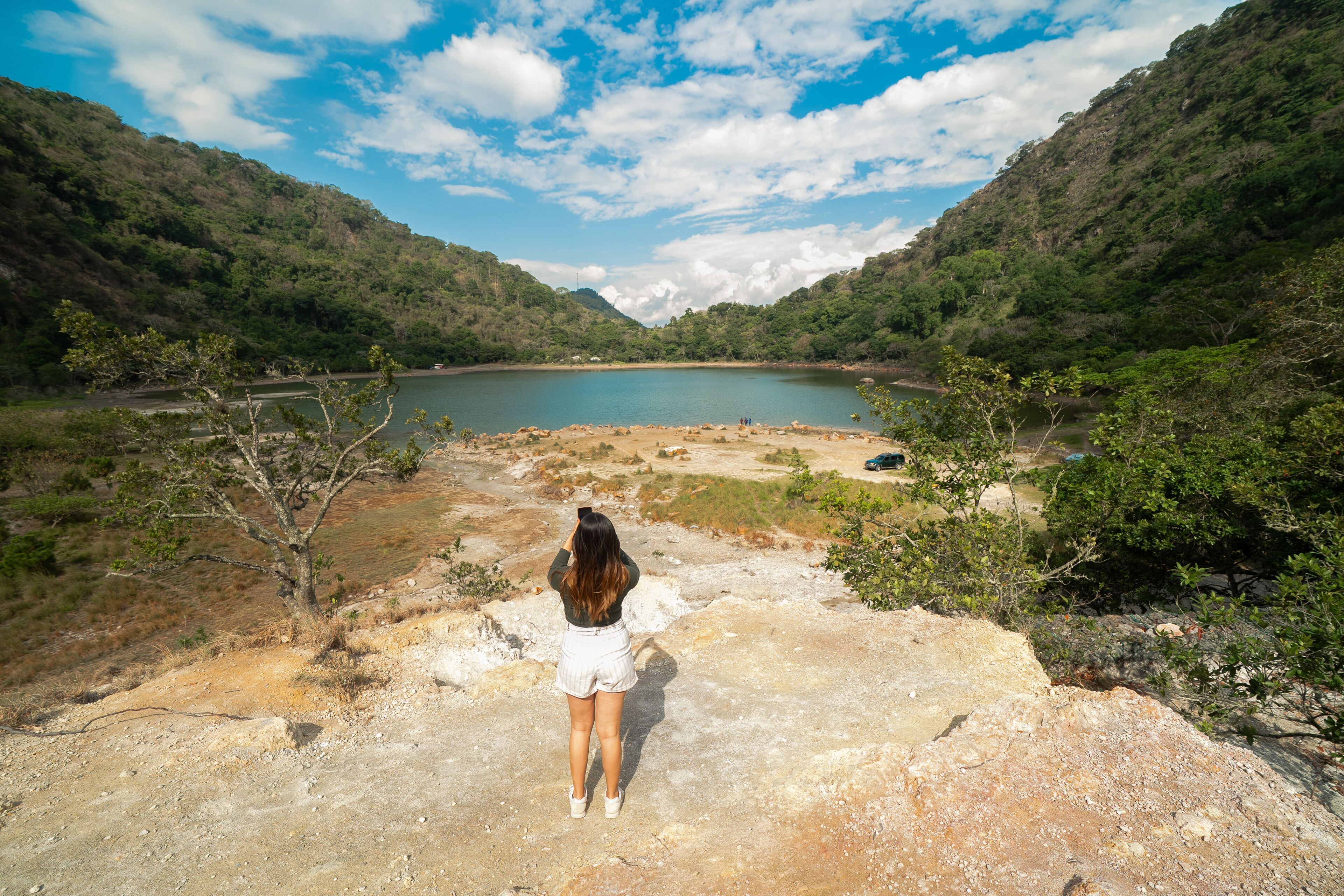 Latin Girl looking a sulfur-rich crater lake located in Alegría, Usulután, El Salvador. Its vibrant greenish color and volcanic origins create a striking natural landscape