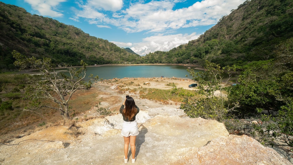 Latin Girl looking a sulfur-rich crater lake located in Alegría, Usulután, El Salvador. Its vibrant greenish color and volcanic origins create a striking natural landscape