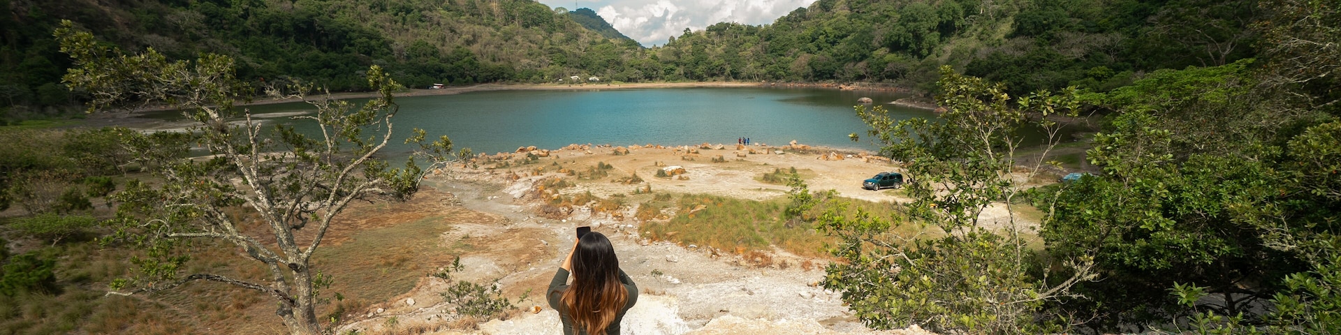 Latin Girl looking a sulfur-rich crater lake located in Alegría, Usulután, El Salvador. Its vibrant greenish color and volcanic origins create a striking natural landscape