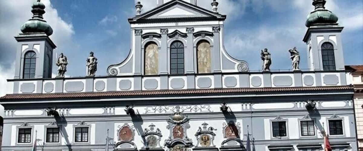 A historic building with ornate architecture, a clock tower, and statues.