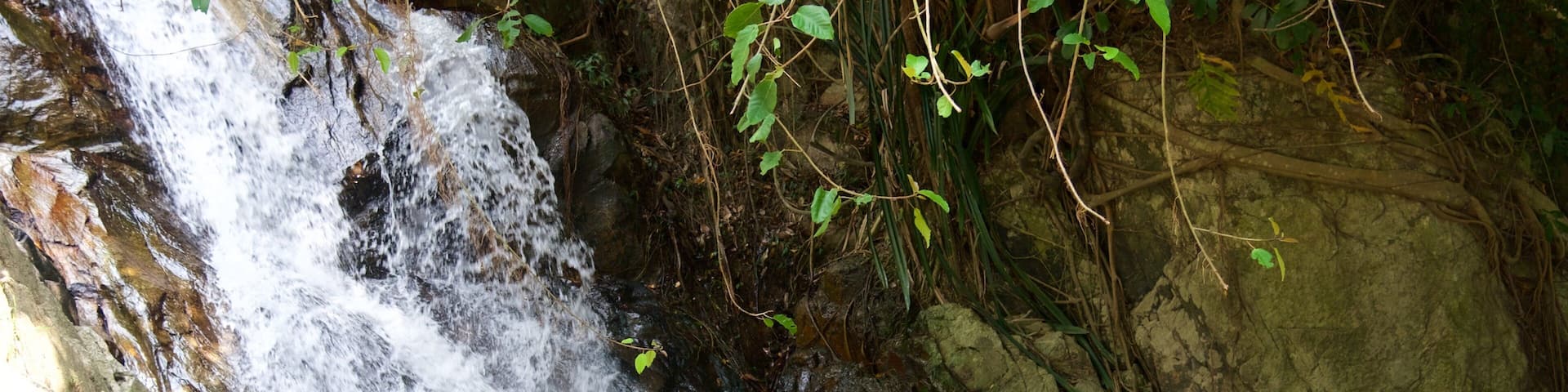 Namuang Waterfall featuring a cascade and a river or creek as well as an individual femail