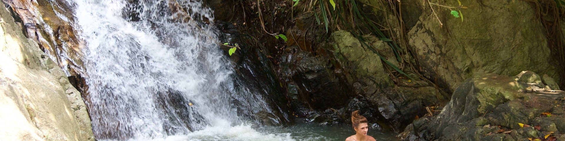 Cascada de Namuang que incluye un río o arroyo y una catarata y también una mujer