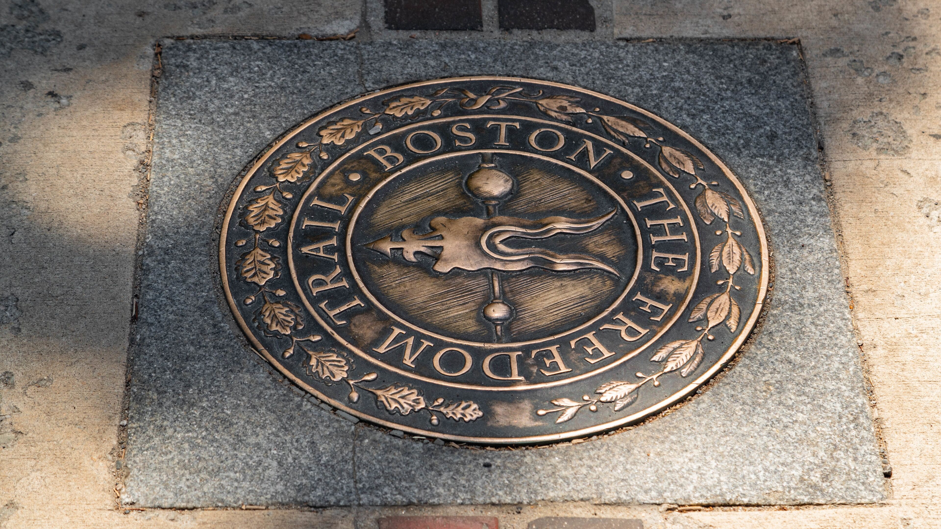 Une plaque métallique portant l’inscription « BOSTON TRAIL » et un emblème décoratif.