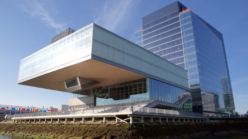 A modern architectural structure with a glass facade and a unique cantilevered section.