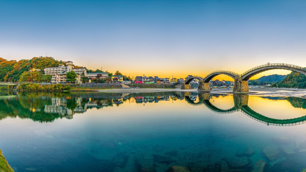 Sunset panorama of Iwakuni and kintai bridge reflected in Nishiki river. Japan