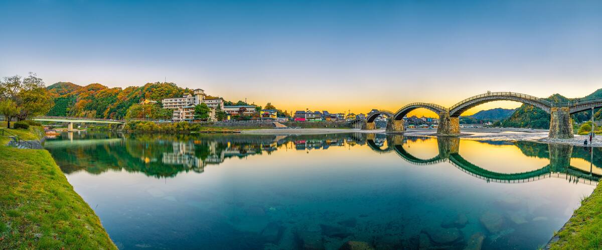 Sunset panorama of Iwakuni and kintai bridge reflected in Nishiki river. Japan