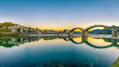 Sunset panorama of Iwakuni and kintai bridge reflected in Nishiki river. Japan