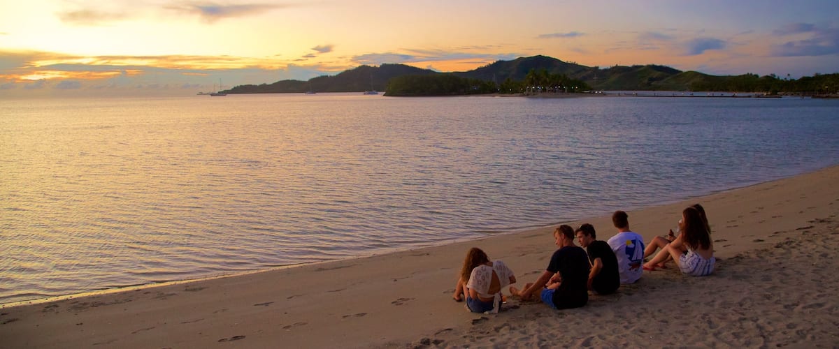 Musket Cove ofreciendo montañas, una playa y una puesta de sol