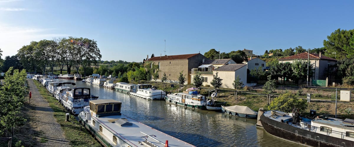 A canal lined with boats and houses.