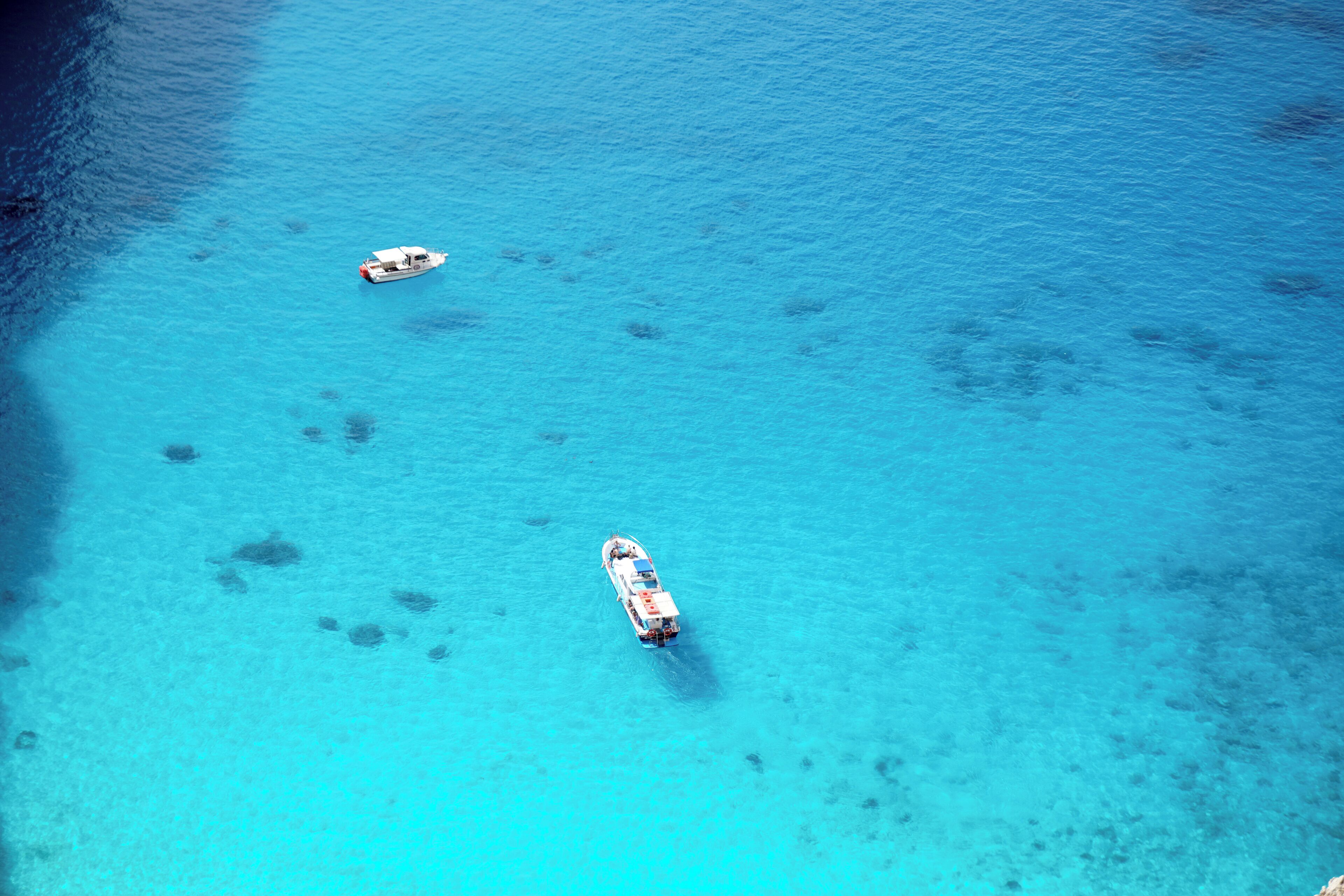Lonely boats casting a shadow in the deep turquoise water of Navagio Beach (Ναυάγιο) #LifeAtExpedia #SeasideDiscoveries