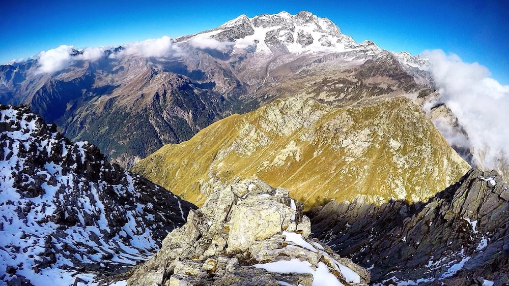 A mountain range with snow-capped peaks and a valley below.