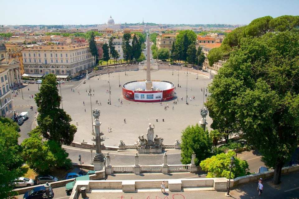 A circular plaza with a central monument, surrounded by trees and buildings.