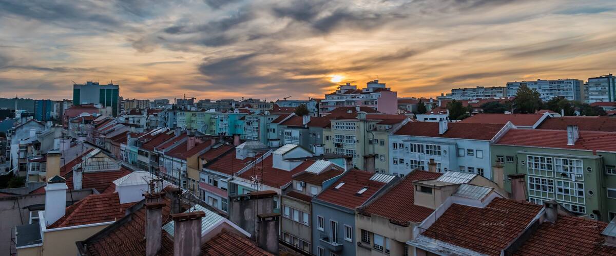 A cityscape with colorful buildings and a sunset in the background.