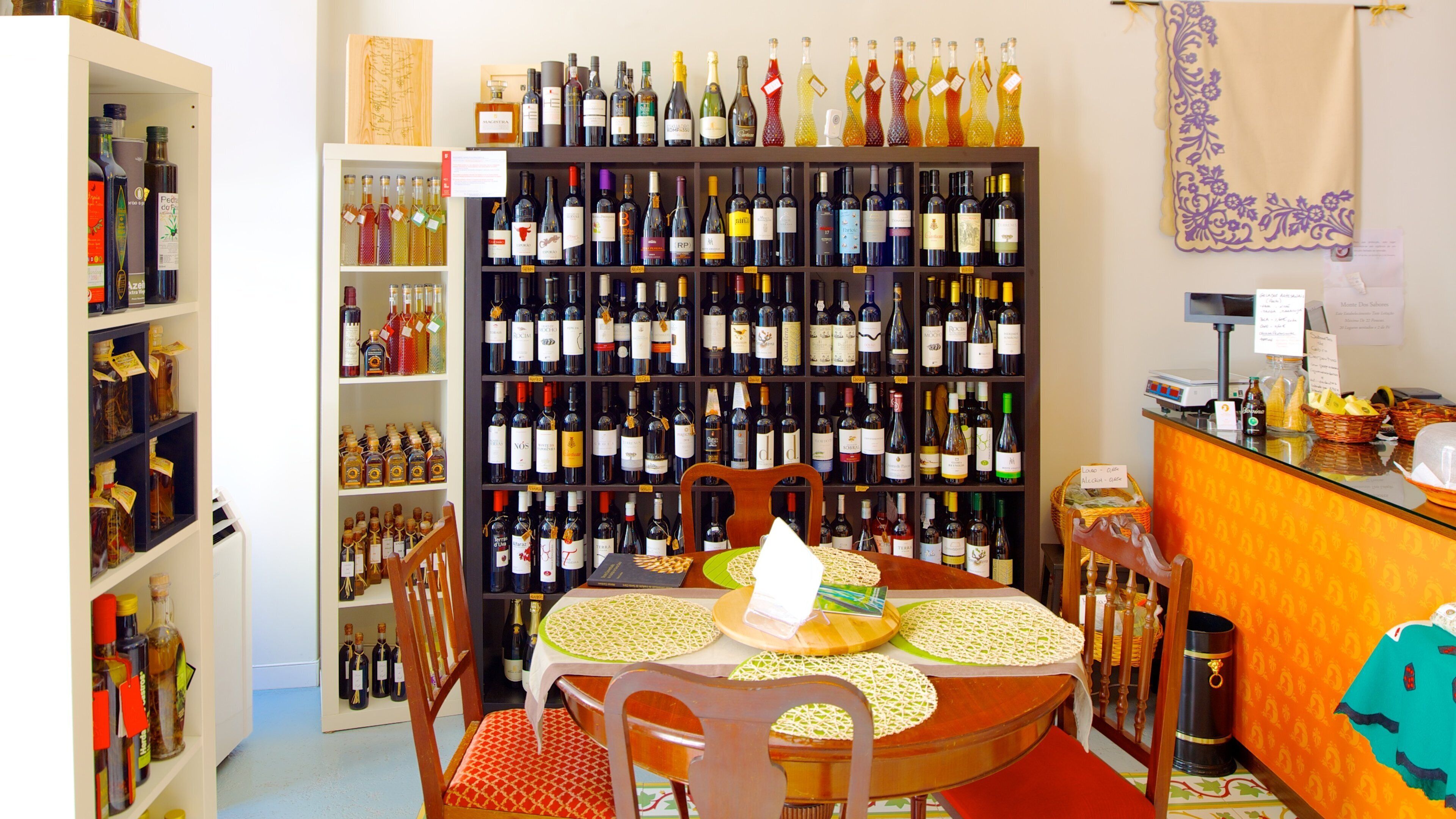 A wine shop with shelves of wine bottles and a table with a placemat.