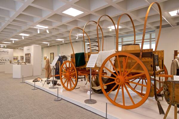 Une exposition de wagons anciens et d’objets connexes dans une galerie.