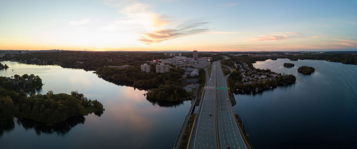 Aerial panoramic view of a Highway in the Modern City during a vibrant Sunset. Taken in Halifax, Dartmouth, Nova Scotia, Canada.