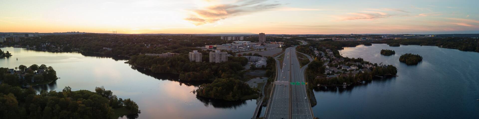 Aerial panoramic view of a Highway in the Modern City during a vibrant Sunset. Taken in Halifax, Dartmouth, Nova Scotia, Canada.