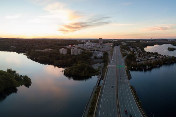 Aerial panoramic view of a Highway in the Modern City during a vibrant Sunset. Taken in Halifax, Dartmouth, Nova Scotia, Canada.