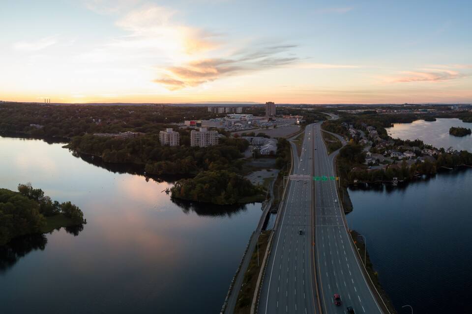 A river with a bridge, surrounded by trees and buildings.