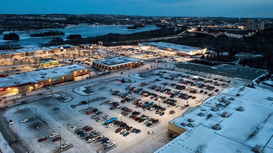 Aerial view of illuminated shopping center and parking lot with vehicles in winter, Dartmouth Crossing, Canada.