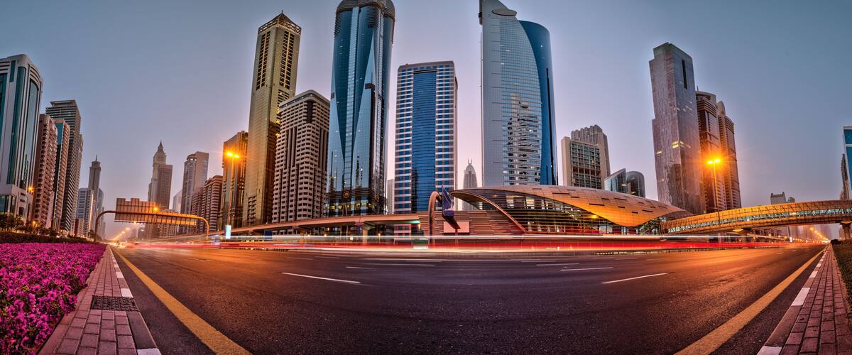 Dubai skyline during sunrise with shining traffic road, United Arab Emirates.