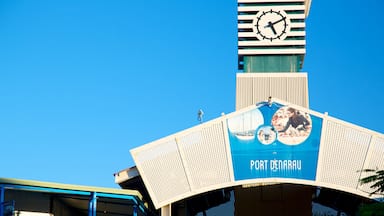 Una torre del reloj y un cartel que dice 'PORT DENARAU' en un edificio.
