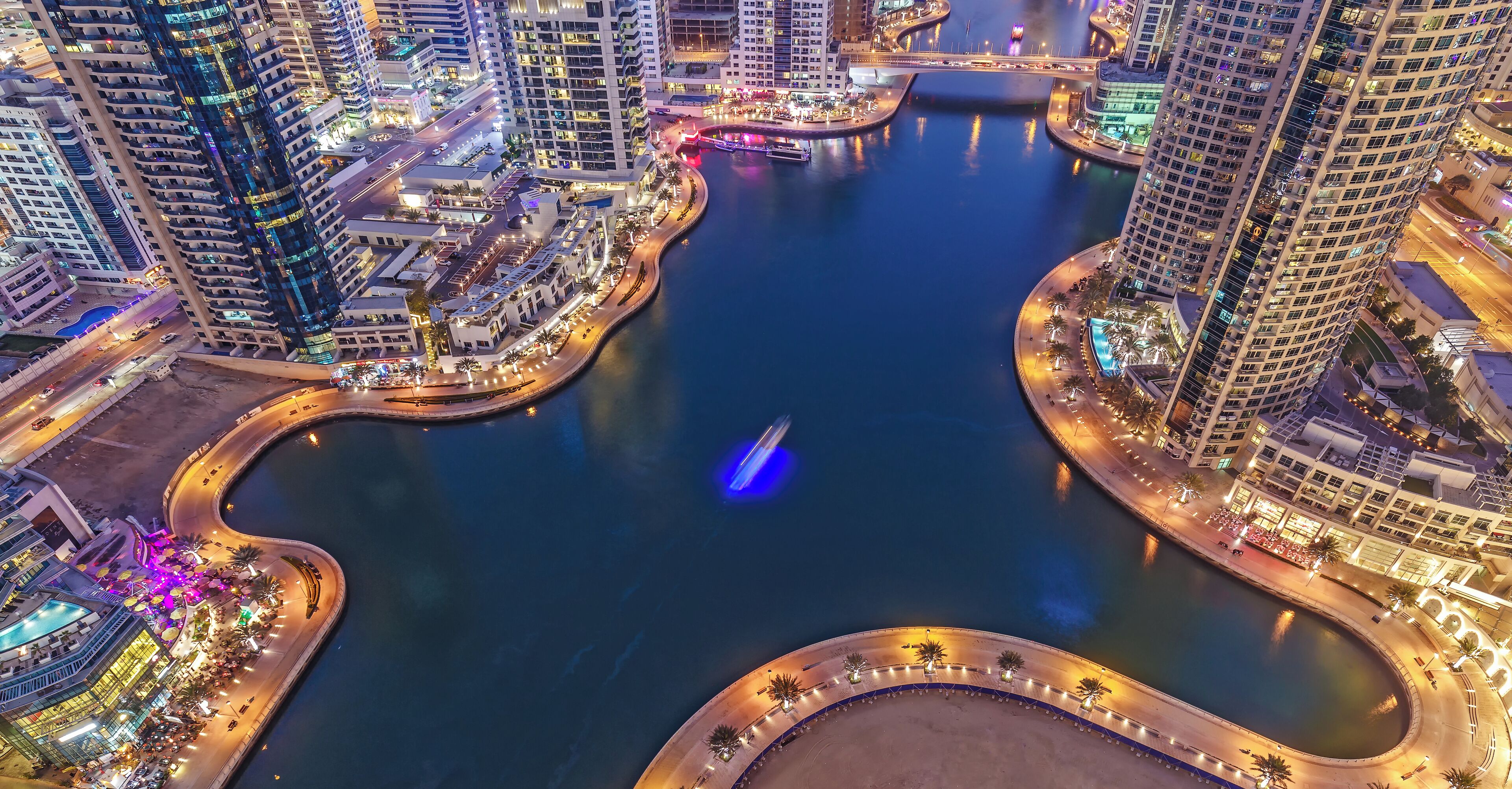 Spectacular view of a big modern city at night. Dubai Marina creek with skyscrapers. Scenic nighttime skyline.