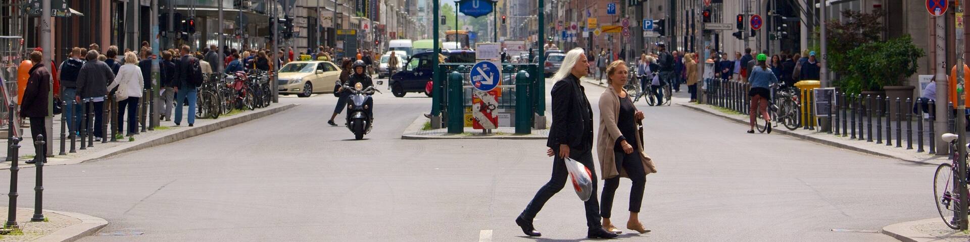 A busy urban street with pedestrians, cyclists, and vehicles.