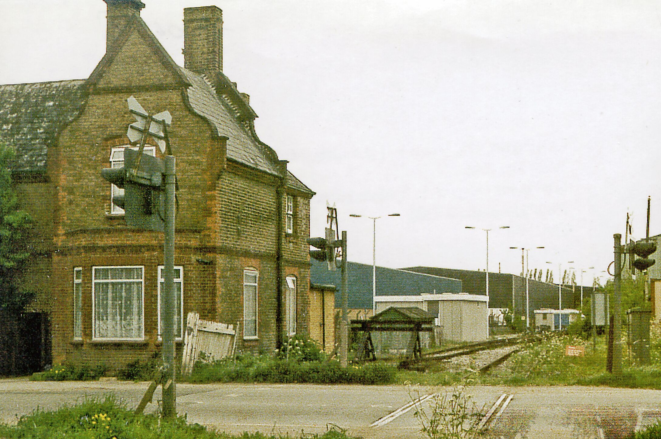 Site of Colnbrook station, 1986, View northward across the B3378 (original Bath Road), towards West Drayton: ex-GWR West Drayton - Staines branch. The station was closed when the passenger service on the branch ceased from 29/3/65. Goods traffic ceased from 3/1/66, but as the photograph shows the line remains open to this point from West Drayton, for traffic to a fuel depot for Heathrow Airport and to an aggregates depot.