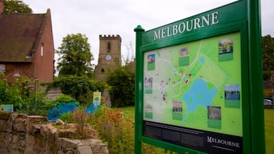 Uma placa verde com a inscrição 'Melbourne', um mapa e uma igreja com uma torre de relógio ao fundo.