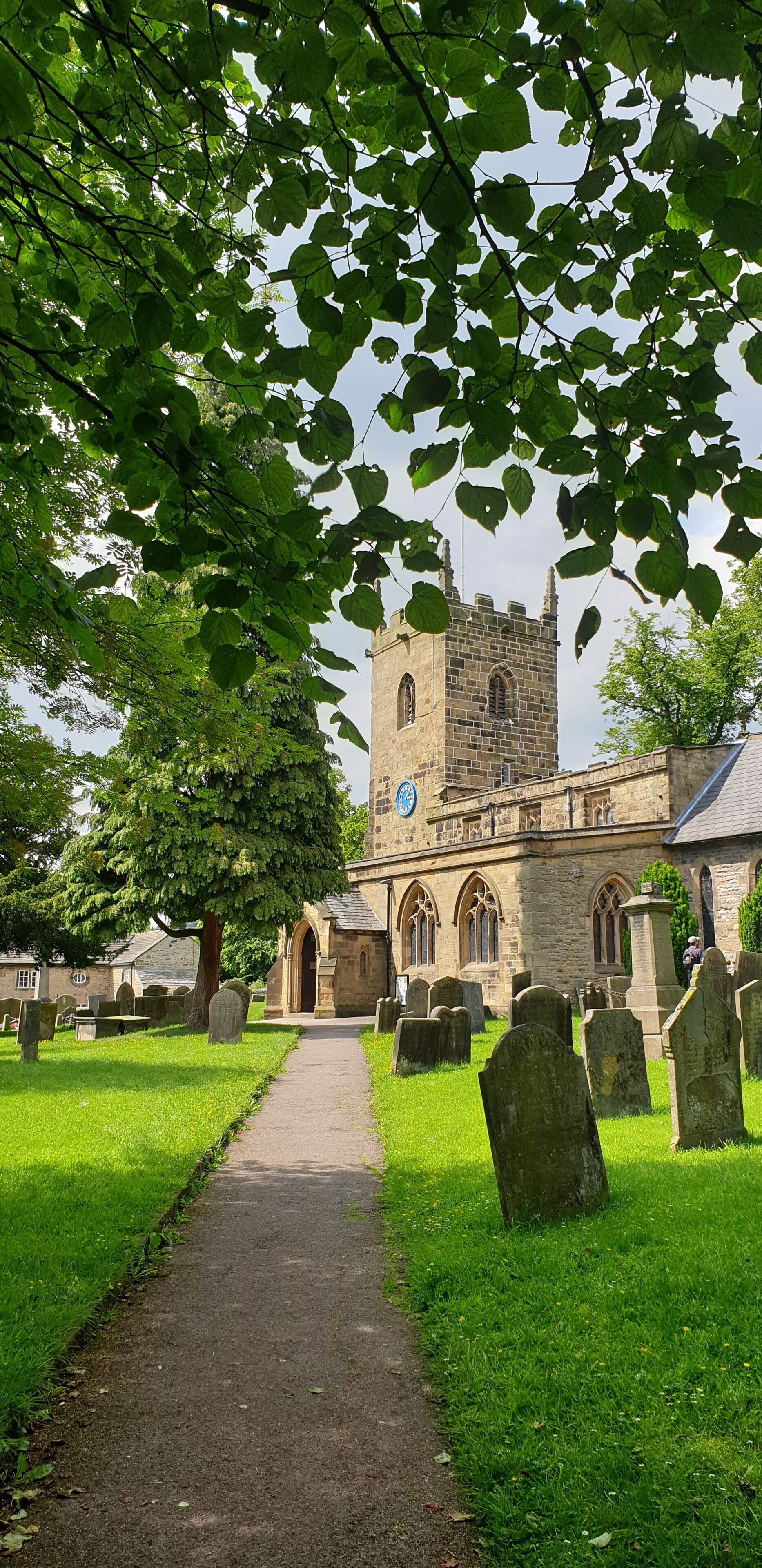 A church with a tower and a graveyard with headstones.