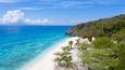 Aerial view of the Sumilon island, sandy beach with tourists swimming in beautiful clear sea water of the Sumilon island beach, Oslob, Cebu, Philippines.
