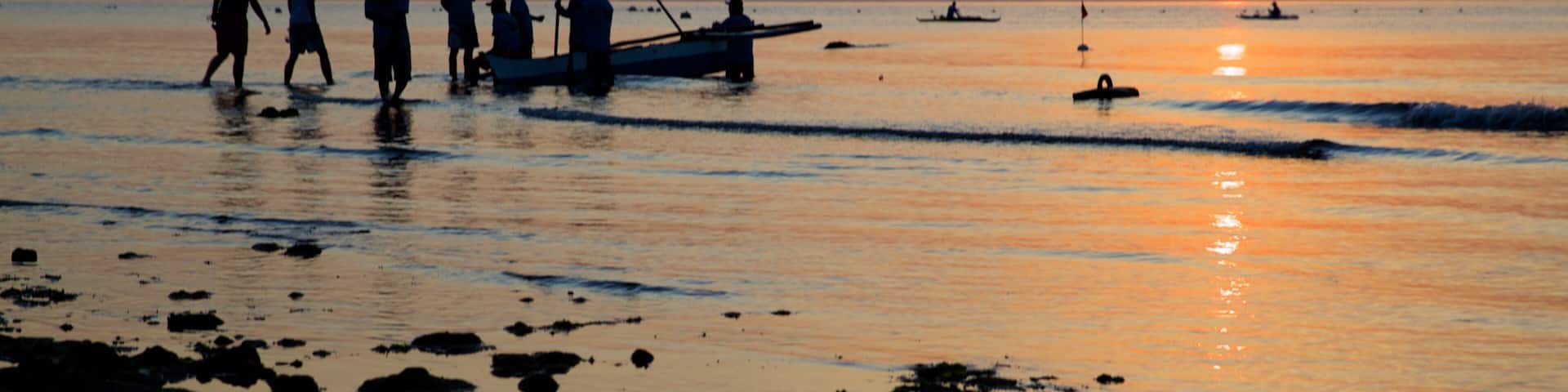 Oslob Beach which includes a sandy beach, general coastal views and a sunset
