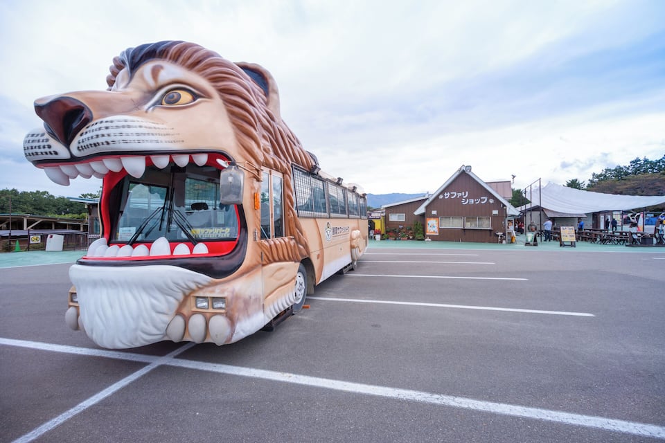 Een bus met een ontwerp van een leeuwenkop geparkeerd op een parkeerplaats.