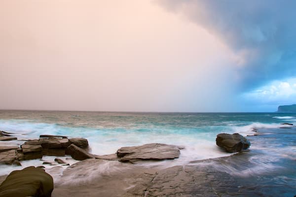 Australian Reptile Park mettant en vedette côte escarpée, coucher de soleil et baie ou port