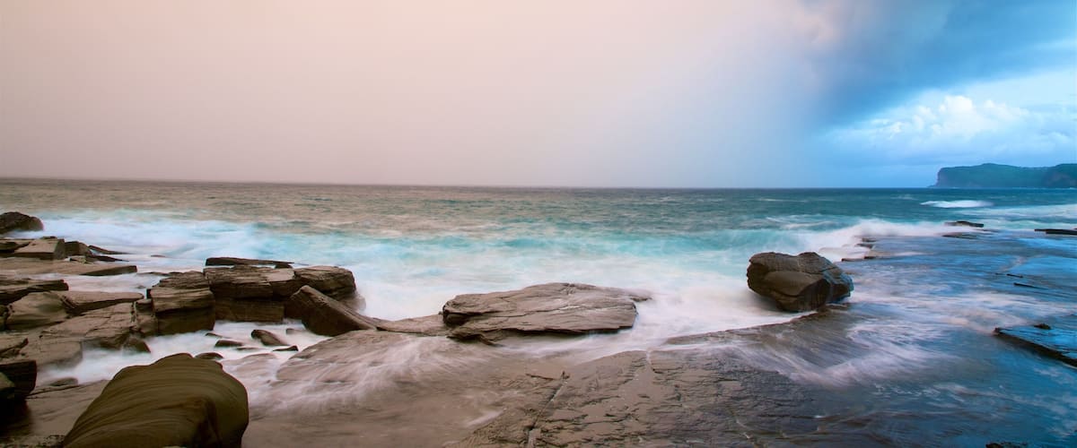 Australian Reptile Park which includes a sunset, rocky coastline and a bay or harbour