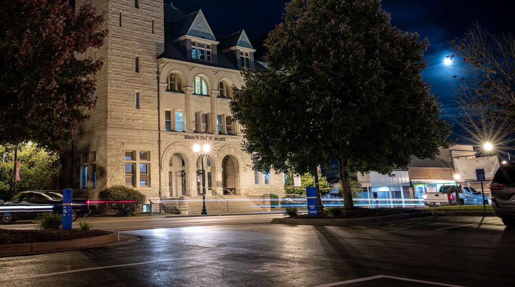 Richmond, Kentucky's Madison County courthouse at night with a full moon behind it and evening traffic crossing in front of the building