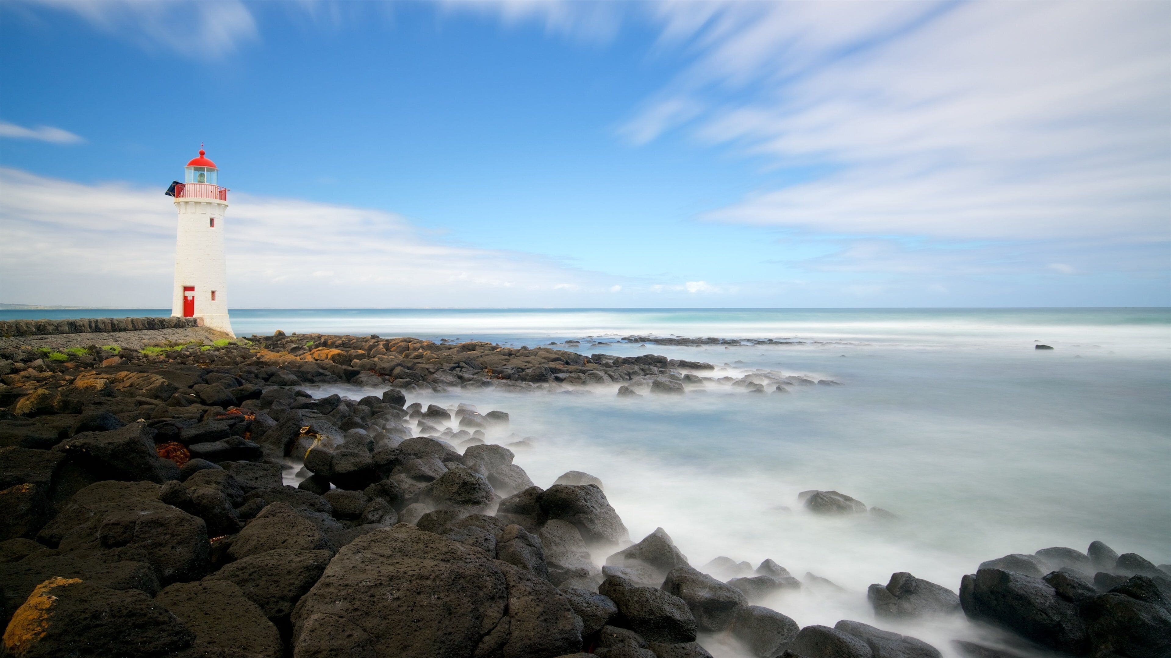 Griffiths Island Lighthouse featuring a bay or harbour, rugged coastline and a lighthouse