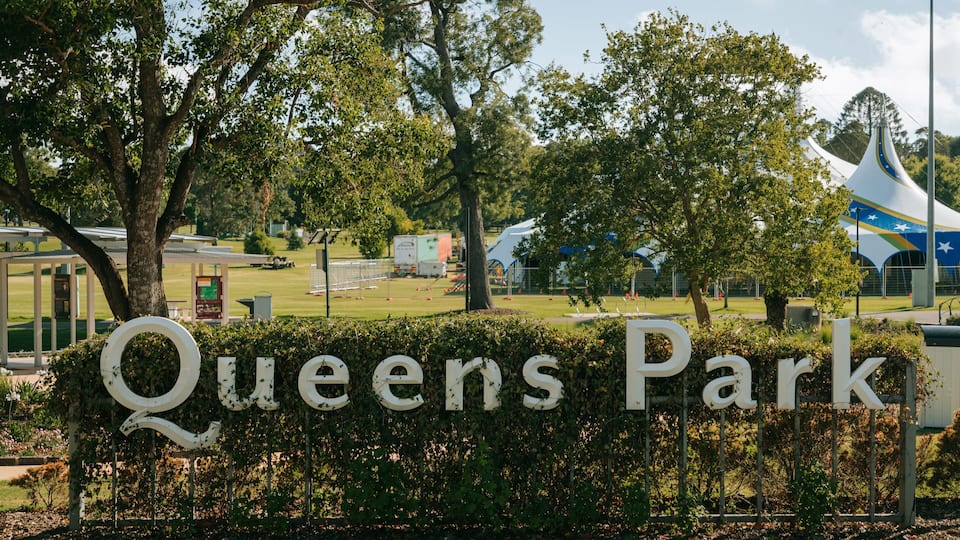 Queens Park featuring a garden and signage