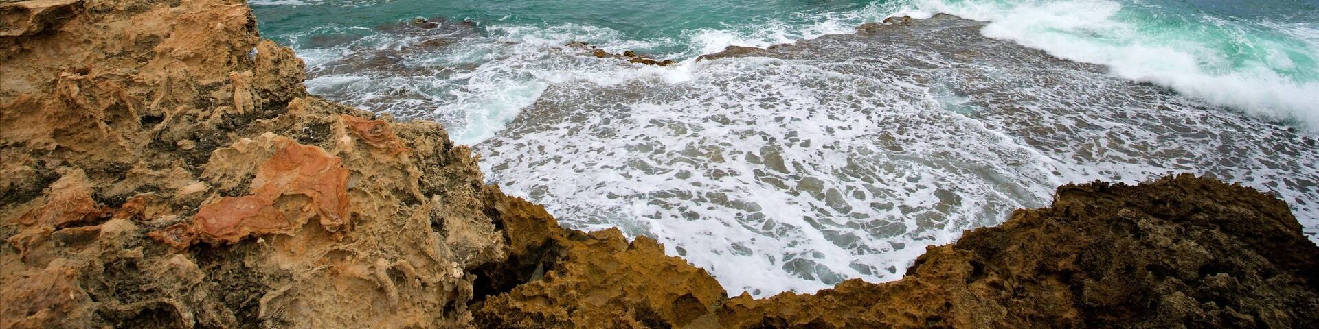 Obelisk Robe som visar kustutsikter, klippig kustlinje och en fyr