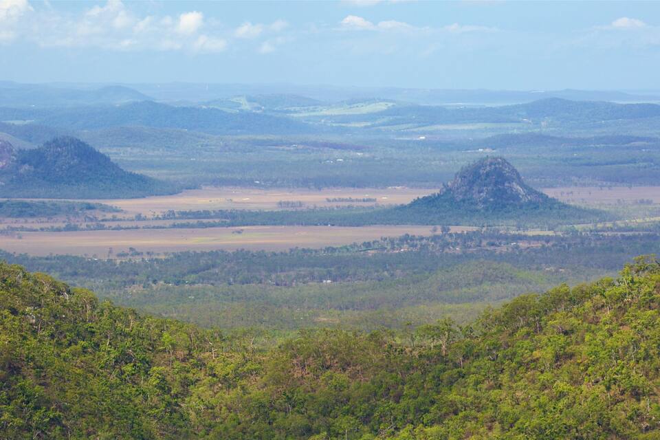 A mountainous landscape with rolling hills and a prominent hill in the center.