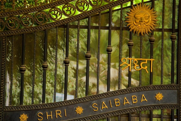 A gate with the inscription "Shri Sai Baba" and a sun symbol.