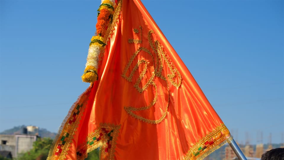 A bright orange flag with golden embroidery and floral decorations.