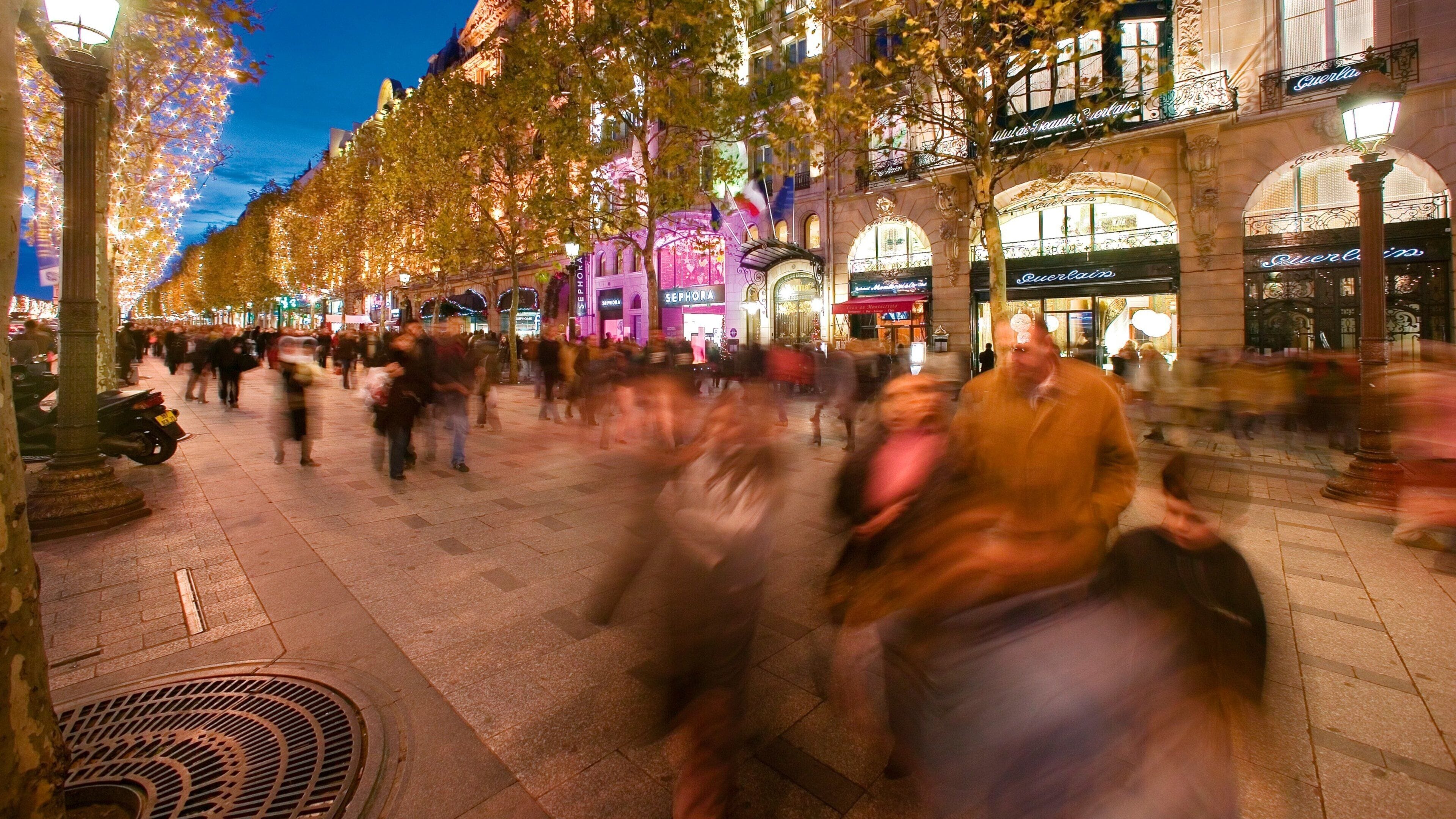 Busy evening on Champs-Elysees in Paris with festive lights and evening crowds