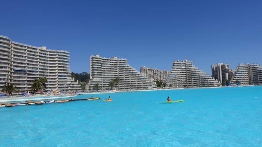 Ein Küstenort mit großen Hotelgebäuden und klarem, blauem Wasser.