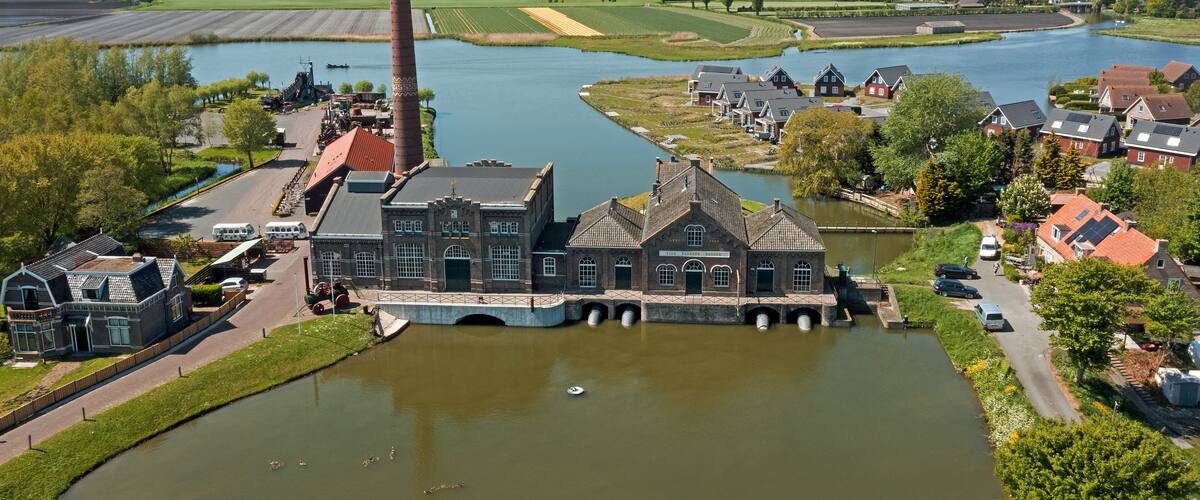 A river with a bridge, industrial buildings, and residential houses.
