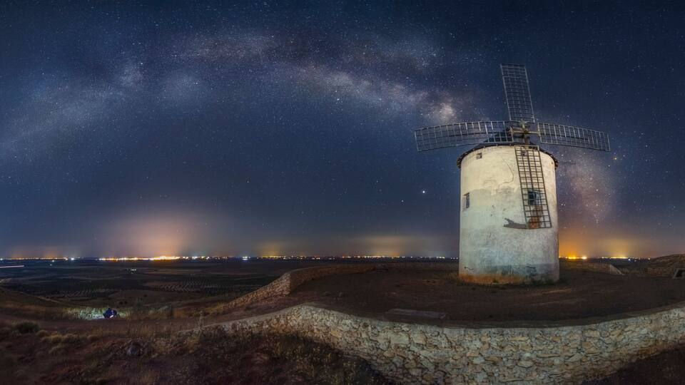 A windmill under a starry sky with the Milky Way visible.