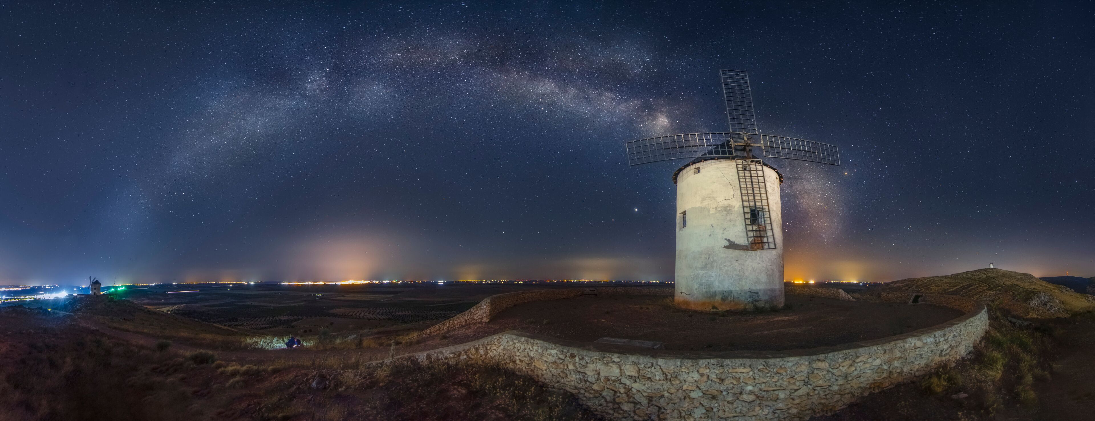A windmill under a starry sky with the Milky Way visible.